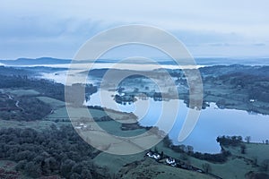 Stunning drone aerial landscape image of cloud inversion around Esthwaite Water in Lake District during Spring sunrise