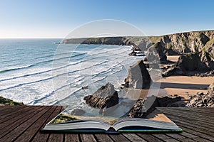 Stunning dusk sunset landscape image of Bedruthan Steps on West Cornwall coast in England coming out of pages of open story book