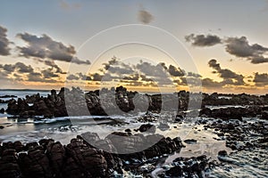 Stunning evening shot of rocks and breaking waves at Cape Agulhas, South Africa`s and therefore Africa`s southernmost point.