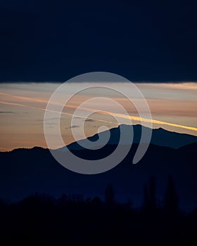 Stunning evening sky featuring vibrant shades of orange streaks across a dark horizon in Klagenfurt