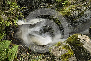 Stunning example of long exposure landscape image showing detail of flowing waterfall at Ashness Bridge in English Lake District