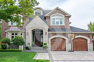A stunning expansive multi level executive home with brown and grey brick stone exterior.