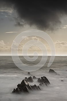 Stunning fine art landscape image of view from Hartland Quay in Devon England durinbg moody Spring sunset