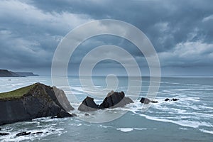 Stunning fine art landscape image of view from Hartland Quay in Devon England durinbg moody Spring sunset