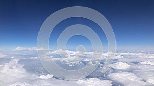 Stunning footage of aerial view above clouds from airplane window with blue sky. view from the airplane window to the