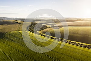 Stunning high flying drone landscape image of rolling hills in English countryside with lovely warm late evening light photo