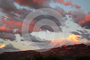 Stunning hot pink clouds over the red mountains at sunset in Tucson Arizona