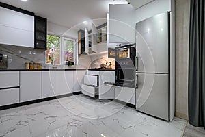 A stunning kitchen with a white, modern design, a luxurious marble floor, and pull-out shelves photo