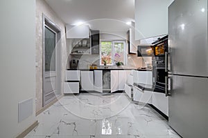 A stunning kitchen with a white, modern design with pull-out shelves for easy access photo