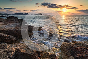 Stunning landscape dawn sunrise with rocky coastline and long exp