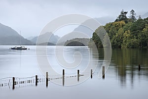 Stunning landscape image of Derwentwater in English Lake District during late Summer with still water and misty mountains in the