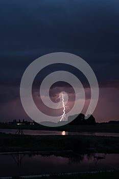 Stunning landscape image of a lightning bolt hitting the ground close to a river