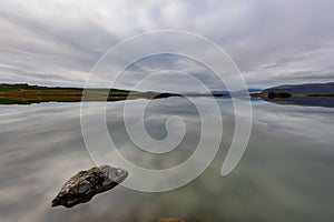 Stunning landscape at Lake Thveit in Iceland. wonder of nature with the sky and the mountain reflected in a mirror of water. Beaut