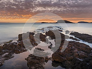 Stunning landscapedawn sunrise with rocky coastline and long exposure Mediterranean Sea