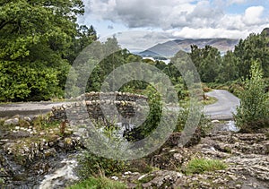 Stunning long exposure landscape image of Ashness Bridge in English Lake District during late Summer afternoon with dramatic