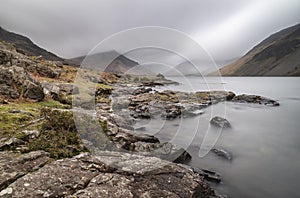 Stunning long exposure landscape image of Wast Water in UK Lake District during moody Spring evening