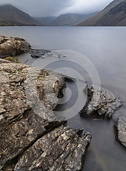 Stunning long exposure landscape image of Wast Water in UK Lake District during moody Spring evening