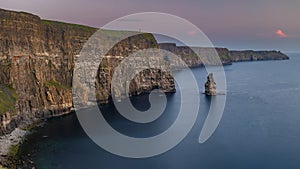 The stunning and majestic Cliffs of Moher in County Clare, Ireland at sunset, beautiful pink sky