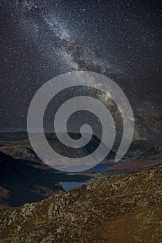 Stunning majestic digital composite landscape of Milky Way over Haystacks and High Stile in Lake District