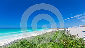 stunning, mesmerizing view of a white sand beach and tranquil,turquoise water on sunny gorgeous day