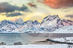 Stunning morning view of Torsfjorden fjord  and snowy mountain peaks at background during sunrise