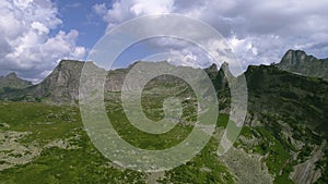 Stunning Mountain Landscape Beneath a Clear Blue Sky Adorned with Fluffy Clouds