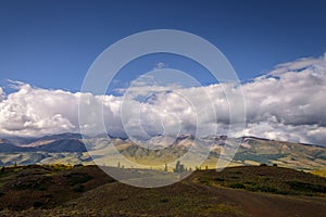 Stunning mountain landscape. Thunderstorm front over the mountain range, sun`s rays shine through fluffy clouds. Beautiful sky.