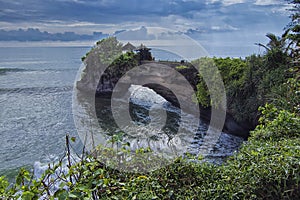Stunning nature view of a temple called Pura Batu Bolong on top of a cliff in Tanah Lot, bali