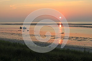 Stunning orange and pink skies from the sun setting over Cape Cod Bay