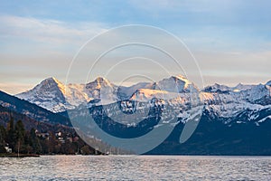 Stunning panorama view of famous Swiss Alps peaks on Bernese Oberland Eiger North Face, Monch, Jungfrau at sunset from Lake Thun