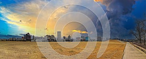 A stunning panoramic shot of the skyscrapers and office buildings in the city skyline with vast yellow winter grass