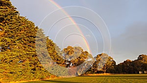 Stunning perfect double rainbow arch over paddocks in Australia