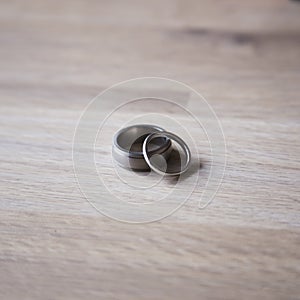 Stunning platinum wedding rings on a pale ash wood background