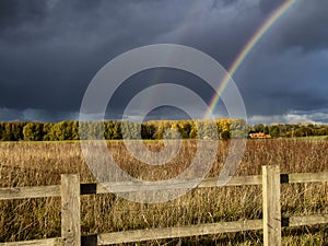 A stunning rainbow against dark clouds over rural fields in Suffolk