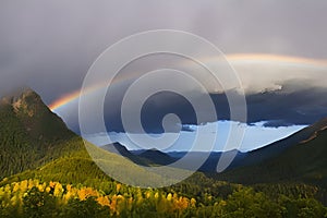Stunning rainbow in stormy skies over the mountains