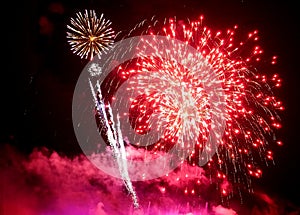 Stunning red fireworks balls exploding on the sky at night