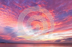 Stunning red and purple and yellow sunset reflecting on the ocean