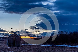 Stunning red sunrise over rustic out building, Springbank, Alberta, Canada