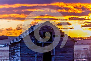 Stunning red sunrise over rustic out building, Springbank, Alberta, Canada
