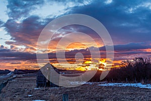 Stunning red sunrise over rustic out building, Springbank, Alberta, Canada