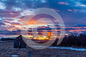 Stunning red sunrise over rustic out building, Springbank, Alberta, Canada