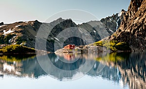 Stunning reflection of Andes mountains and Refugio Italia Manfredo Segre in Laguna Negra lake in Patagonia, Argentina. Winter back photo