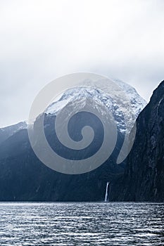 A stunning scene of nature with snow mountain and waterfalls at Milford Sound, New Zealand. I
