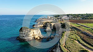 Stunning seascape with cliffs rocky arch and stacks (Faraglioni) at Torre Sant Andrea, Salento coast, Puglia region