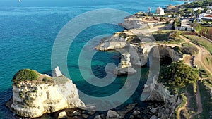 Stunning seascape with cliffs rocky arch and stacks (Faraglioni) at Torre Sant Andrea, Salento coast, Puglia region