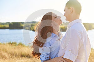 Stunning sensual outdoor portrait of young stylish fashion couple hugging in summer in field. The concept of love, trust and