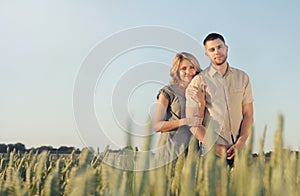 Stunning sensual young couple in love posing in summer field