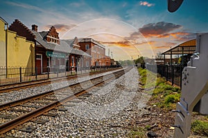 A stunning shot of the railroad tracks covered in gravel with lush green grass on the edges