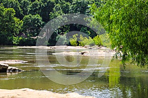 A stunning shot of the silky brown waters of the Chattahoochee river with vast miles of lush green trees along the river