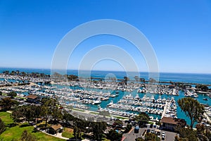 A stunning shot of the vast blue ocean water with white boats and yachts docked in the harbor and sailing in the harbor